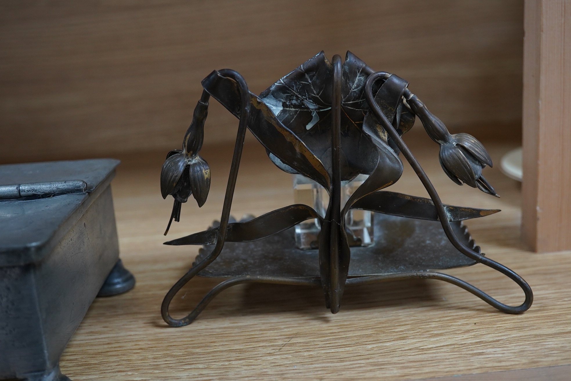 A Georgian pewter standish, 18cm wide, and an inkwell on a brass frame in the form of a fuchsia. Condition - fair